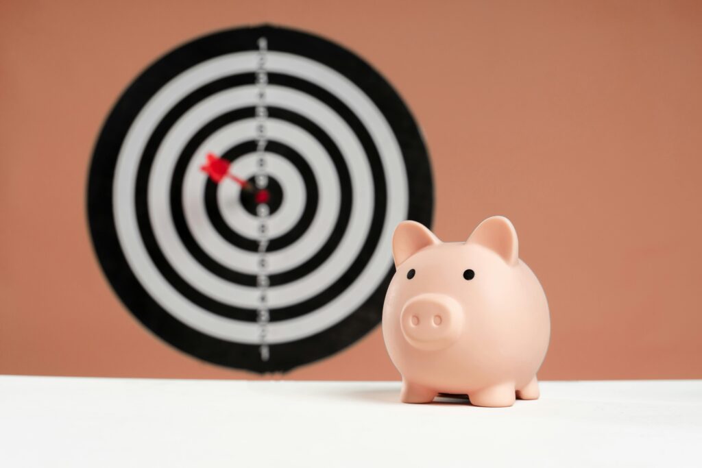 A piggy bank in front of a dartboard symbolizing financial goals and smart savings. Long-term goals