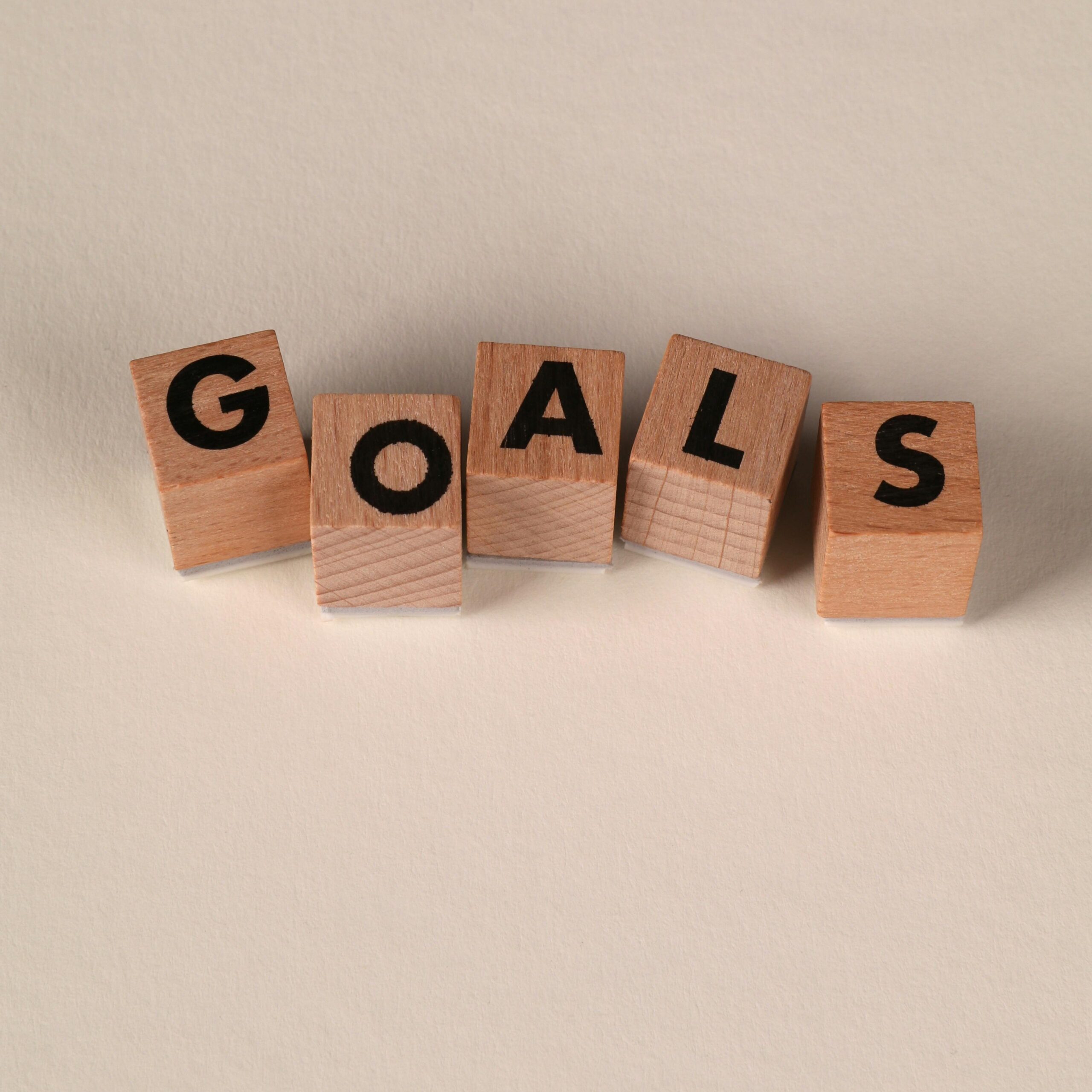 Wooden blocks spell out 'Goals' on a neutral background. Perfect for motivation themes. Smart Goals Kaise Set Kare