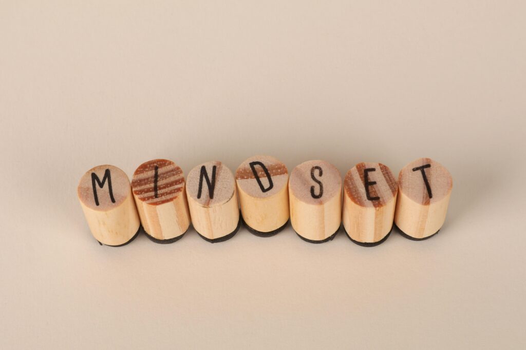 Wooden letter stamps spelling 'Mindset' on a simple beige background, conveying focus and positive thinking. Mindset: Zero Se Paise Banana Kaise Start KareSuccess Ki Foundation