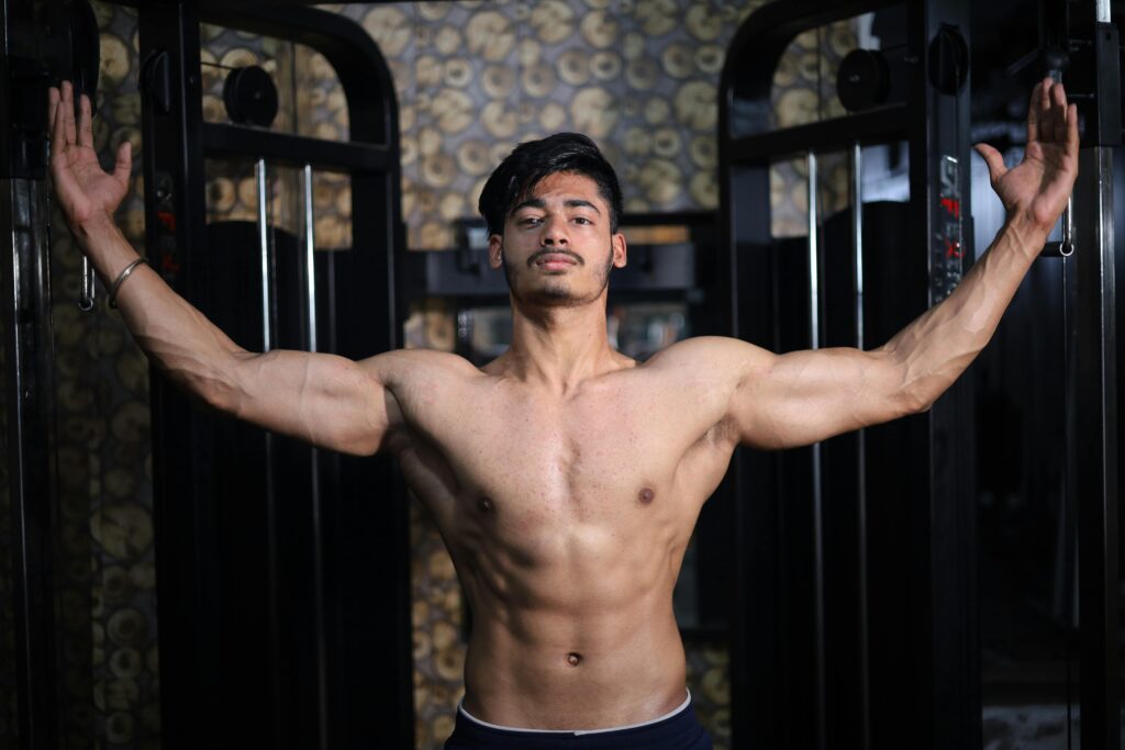 A shirtless South Asian man shows off his muscular physique while posing in a gym setting.
Fit and Strong