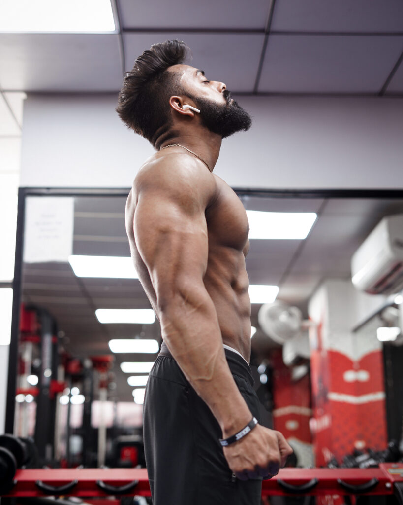 Side view of a muscular man in a gym environment showing strength and focus.
Fit Body Kaise Banaye 