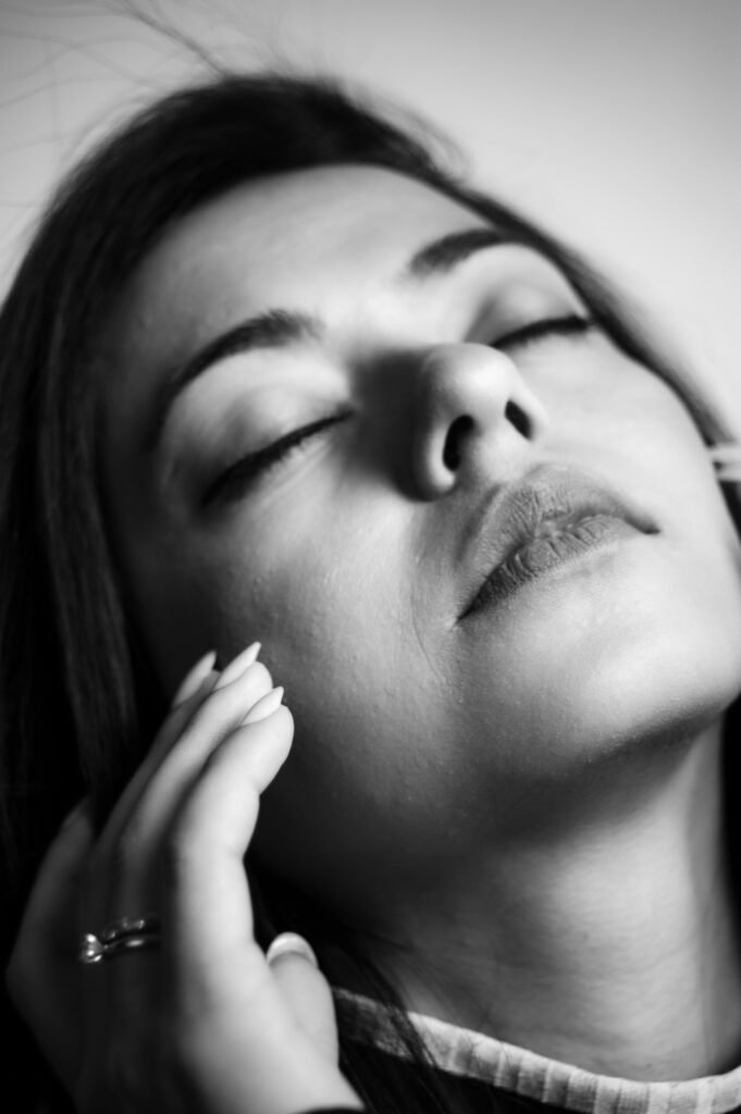 A serene black and white portrait of a woman with closed eyes, conveying calmness.