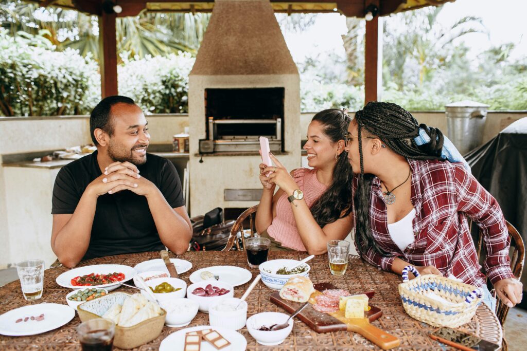 A group of friends enjoying a casual meal outdoors, sharing laughter and good food.