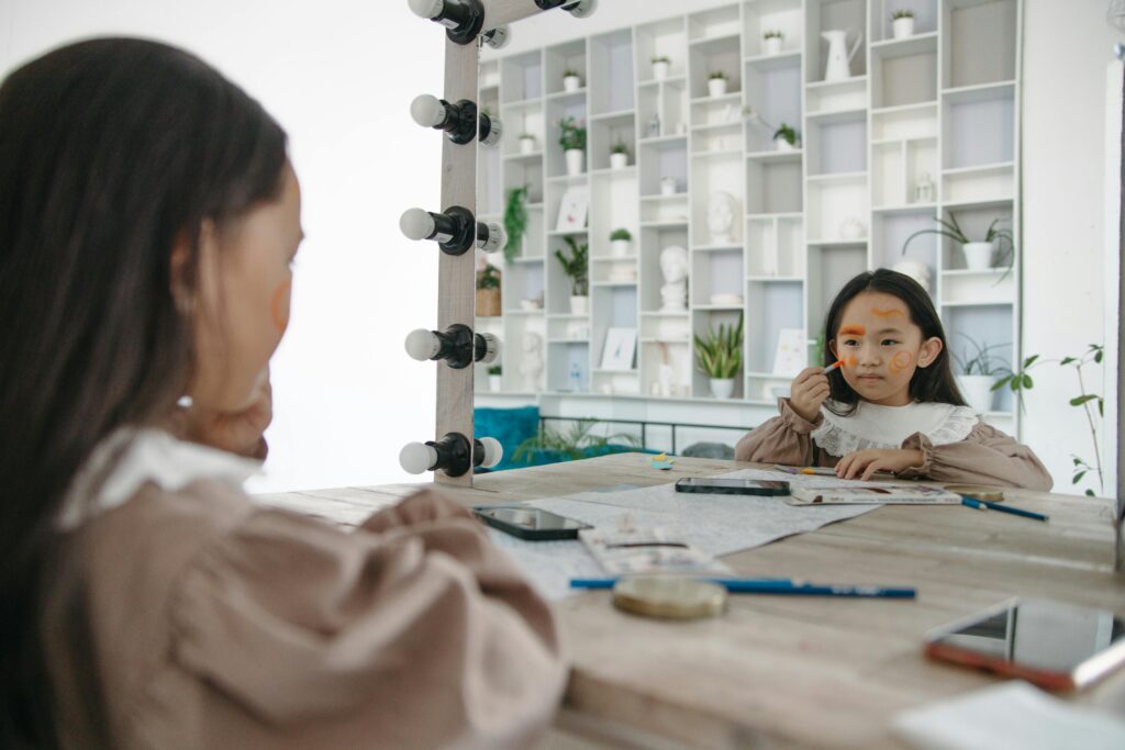 A young girl applies face paint while looking at her reflection in a vanity mirror.
Public Speaking Kaise Sikhe