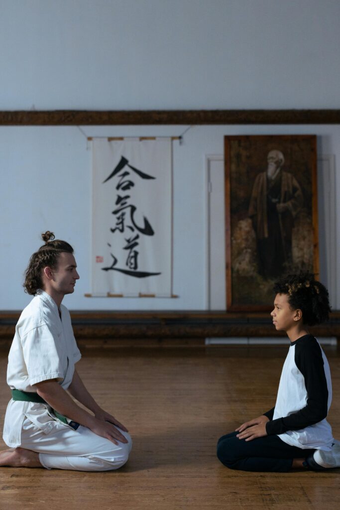 Two individuals kneeling face-to-face in a martial arts dojo, learning aikido.
Life Me Discipline Kyun Zaruri Hai