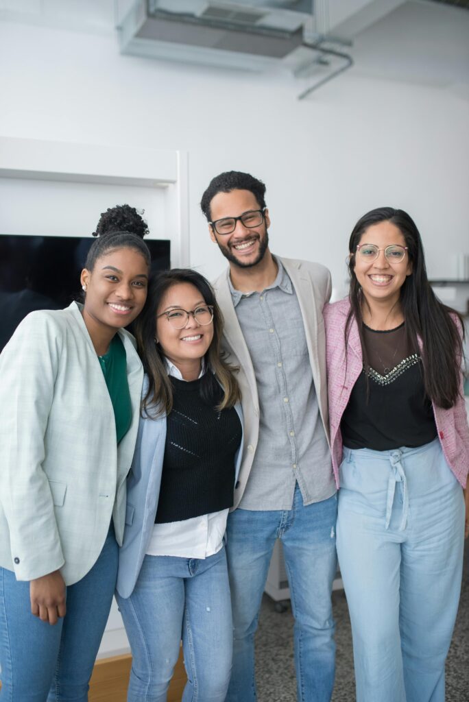 Group of diverse young professionals smiling in an office setting, showcasing teamwork.
Body Language Ka Importance