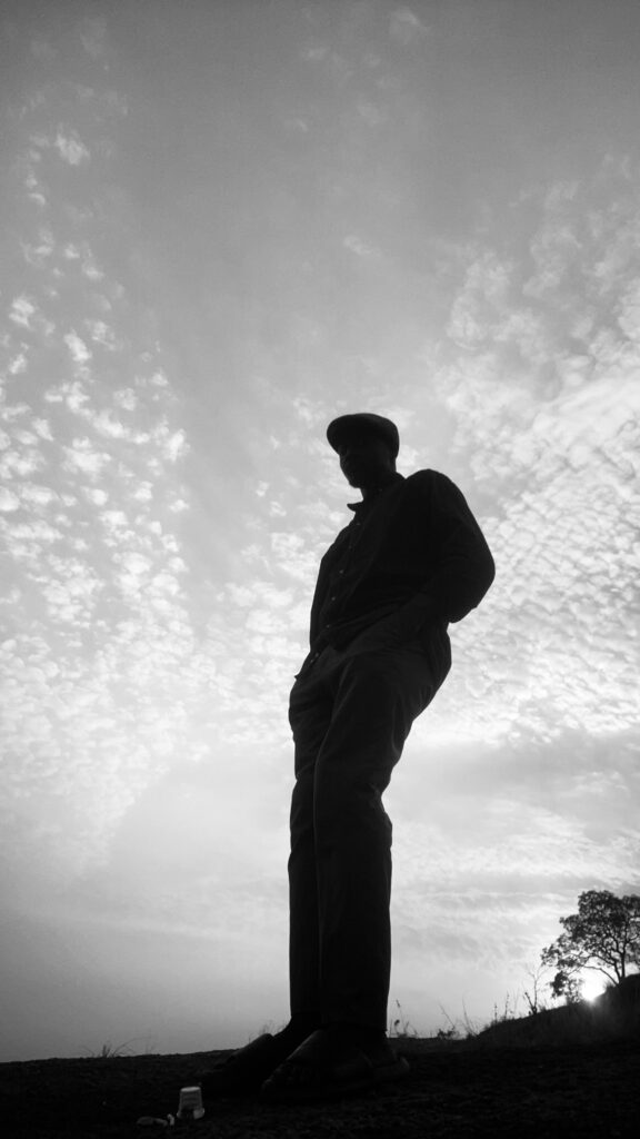 A striking silhouette of a man against a cloudy sky at sunset.