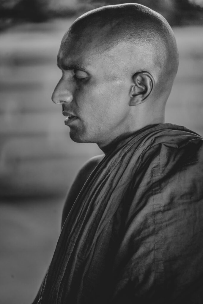 Black and white portrait of a meditative monk in traditional robe capturing serenity and focus.