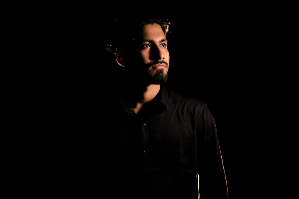 Dramatic low-key portrait of a man in deep contemplation.