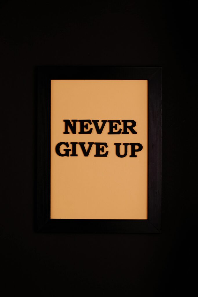 A framed motivational quote 'Never Give Up' against a black background.