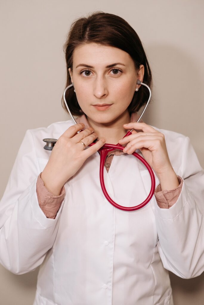 Portrait of a female doctor confidently holding a red stethoscope, showcasing professionalism.
