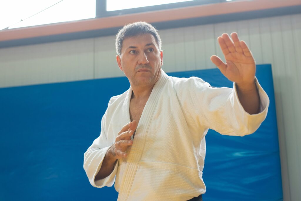 A martial artist performing judo techniques indoors, showcasing skill and concentration.