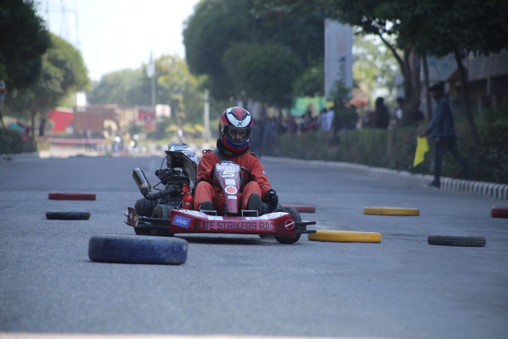 Exciting go kart racing event with drivers on an outdoor track navigating obstacles.