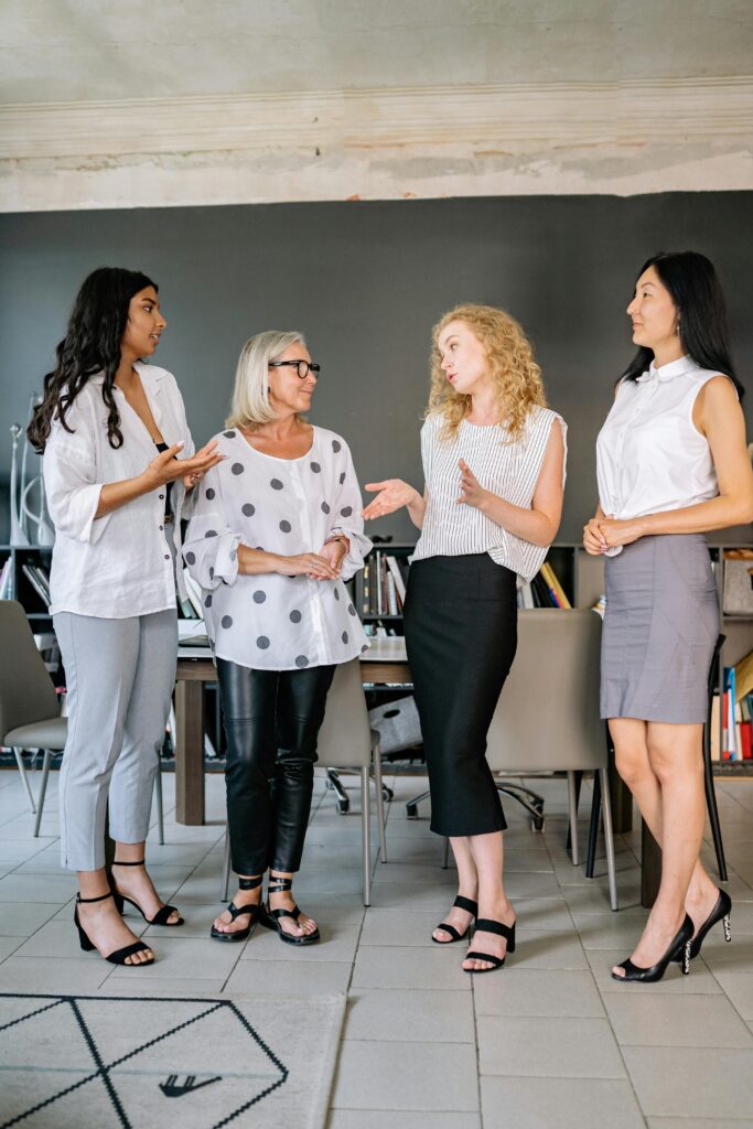 A diverse group of businesswomen having a discussion in a modern office setting.