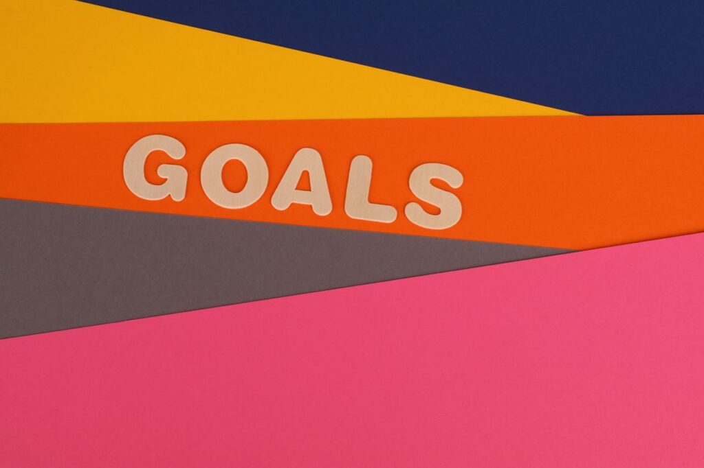 Vibrant abstract image with the word 'Goals' on multi-colored paper background.