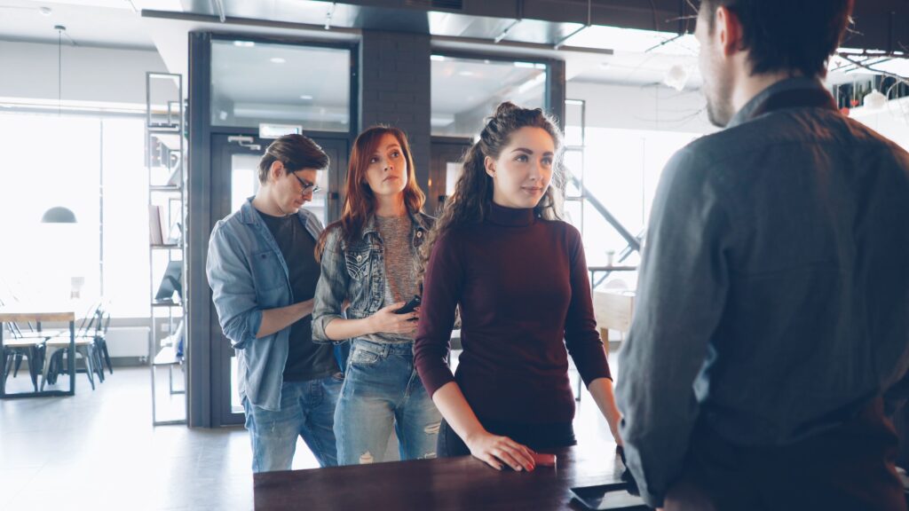 Diverse group of customers waiting in line at a modern cafe with natural lighting. 
अपनी Identity Strong कैसे बनाएं?