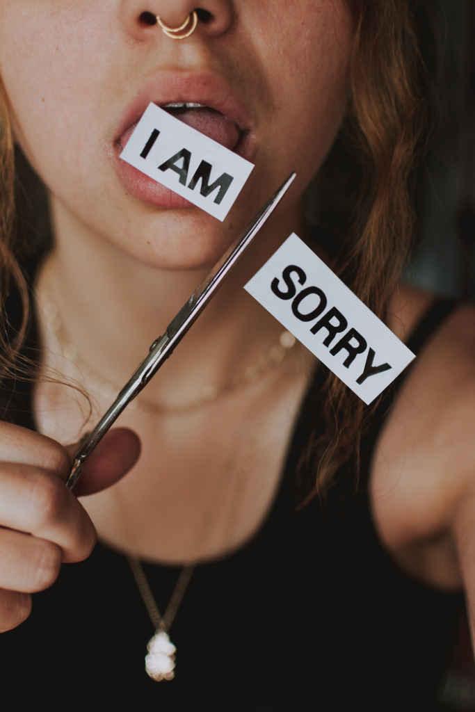 Crop unrecognizable female with piercing showing tongue and demonstrating selfishness and disregard for people